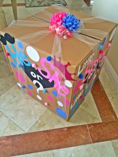 a large brown box with pink, blue and white decorations on it sitting on the floor