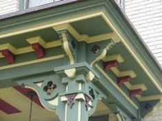 an ornate green and yellow building with red trim