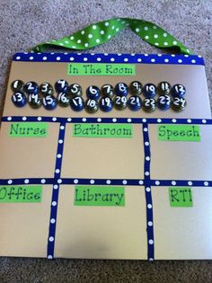 a bulletin board with numbers and letters on it, sitting on the floor next to a green ribbon