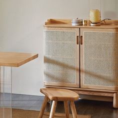 a wooden cabinet sitting on top of a hard wood floor next to a table and chair