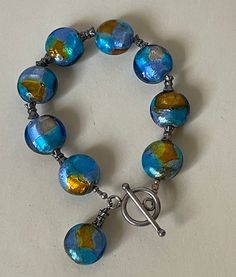 "Multi Pastels, blue, multi-color Murano glass, sterling silver 925 clasp and beads bracelet. Handmade.  Marked: 925.  All sizes approximately:  Murano beads - 5/8\"  L - 7.5\" with clasp ( photos, my  wrist is  6.5\")   Very good vintage condition.  Domestic shipping: USPS First class mail. 1-5 business days. I can file an insurance claim only after 20 business days after item was shipped International shipping: USPS First class mail. Approximately 7-21 business days. I can file an insurance cl Blue Czech Glass Beaded Bracelets With Lobster Clasp, Blue Beaded Bracelets With Lobster Clasp In Czech Glass, Silver Glass Bracelets With Large Beads, Blue Single Strand Bracelets With Round Beads, Blue Single Strand Bracelet With Round Beads, Blue Beaded Bracelets With Sterling Silver Clasp, Blue Sterling Silver Bracelets With Polished Beads, Blue Bracelets With Sterling Silver Clasp, Blue Bracelet With Sterling Silver Clasp