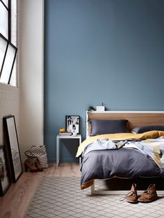 a bed room with a neatly made bed and blue walls