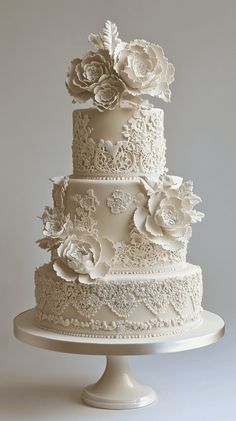 a three tiered wedding cake with white frosting and flowers on the top layer