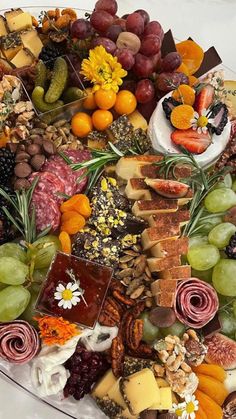 a heart shaped platter filled with different types of cheeses, fruit and nuts