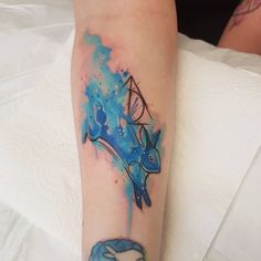 a person with a tattoo on their arm that has a blue and black dolphin in it