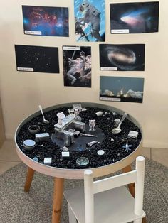 a table that has some pictures on the wall behind it and an object in the middle