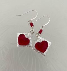 Say I LOVE YOU with these lovely Red and Silver Heart Earrings.  They are hand made  They are made of a silver dichroic glass and clear red glass and fused in a kiln.  The wires are Sterling Silver.  Great as an I love you gift, a Valentine's Day gift, birthday or anniversary gift.   I'm sure she will love them! Adjustable Red Heart Earrings For Gift, Red Sterling Silver Dangle Heart Earrings, Handmade Red Heart Earrings For Anniversary, Handmade Red Heart Sterling Silver Earrings, Handmade Red Heart Earrings In Sterling Silver, Red Heart Earrings With Ear Wire For Gift, Wire Wrapped Heart Earrings For Gift, Wire Wrapped Heart Earrings As Gift, Valentine's Day Clear Glass Jewelry