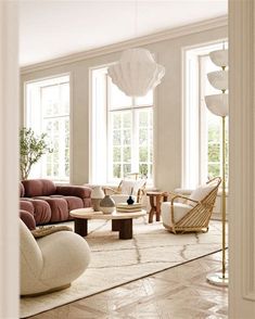 a living room filled with furniture and large windows