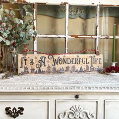 a sign that says it's a wonderful life sitting on top of a dresser