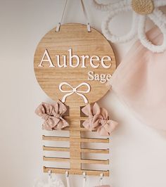 there is a wooden sign that says aubree sage on the wall next to two baby shoes