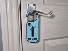 a door handle with a sticker on it that says in use and an image of a person holding a shower head