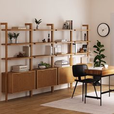 a dining room table with chairs and bookshelves in front of a clock on the wall