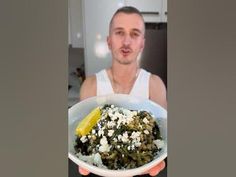 a man holding a white bowl filled with food