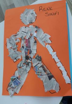 a child's handmade paper cut out of newspaper with an image of a man