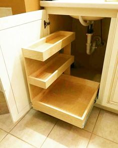 an open cabinet in the corner of a kitchen with a sink and countertop area