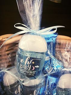 a basket filled with baby shower products and wrapped in blue plastic wrappers, sitting on top of a table