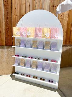 an assortment of small bags on display in front of a wooden fence with snowflakes hanging from it