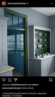 an image of a kitchen with blue cabinets and white dishes on the counter top in front of it