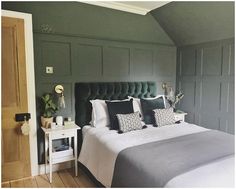 a bedroom with green walls and white bedding in the corner, along with two nightstands