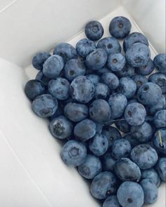 a pile of blueberries in a white box