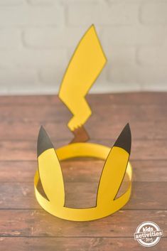 a yellow and black paper crown sitting on top of a wooden table