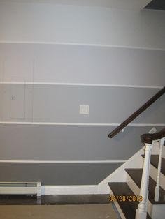 an empty room with striped walls and stairs