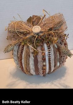 a decorative pumpkin decorated with ribbons and beads