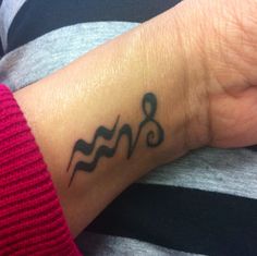 a person with a tattoo on their wrist has a musical note tattooed on the wrist