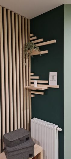 a room with green walls and wooden shelving on the wall next to a radiator