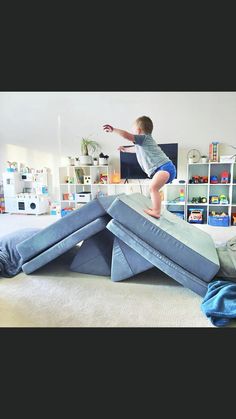 a young boy is jumping on top of an inflatable structure with his arms outstretched