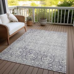 a white and blue rug sitting on top of a wooden floor next to a chair