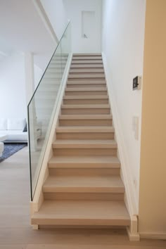 a set of stairs with glass railings leading up to the second floor in a modern home