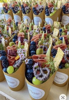 a table topped with cups filled with different types of fruit and veggies on top of each other