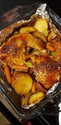 chicken, potatoes and carrots are in a baking dish on the stove with tin foil