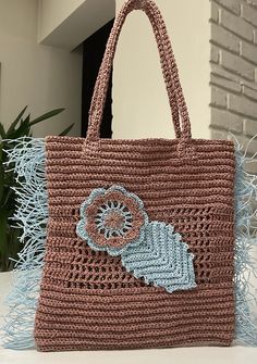 a crocheted bag with a flower on the front and an applique in the back