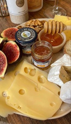 a plate with cheese, figs and honey on it