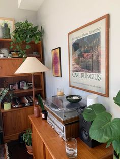 a living room with a record player, plant and pictures on the wall