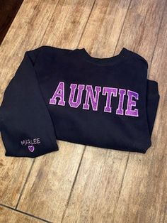 Custom Embroidered Glitter Sweatshirt. Nana, Lala, Aunt, Mom, Mama, Sis, Auntie, Grammy, Grandma, or any personalized name. Varsity T-shirt With Letter Embroidery, College T-shirt With Custom Embroidery For School Spirit, College School Spirit T-shirt With Custom Embroidery, Black College Sweatshirt With Embroidered Text, Custom Embroidery Team Spirit Sweatshirt For College, College Team Spirit Sweatshirt With Custom Embroidery, College Team Spirit Tops With Custom Embroidery, Embroidered Tops For College Sports Season, Black College Top With Letter Embroidery