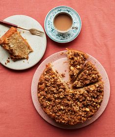 a plate with a piece of cake on it next to a cup of coffee