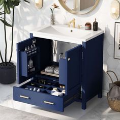 a bathroom with a sink, mirror and blue cabinet in the corner next to a potted plant