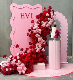 a pink and red floral arrangement next to a sign with the word evi on it