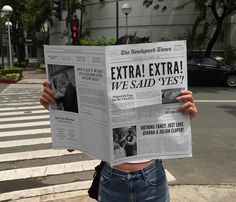 a woman holding up a newspaper with the words extra extra we said yes