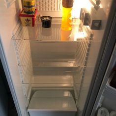 an open refrigerator with the door wide open and food in it's bottom shelf