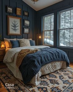 a bed sitting in a bedroom next to a window covered in blue blankets and pillows