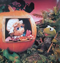 the muppet and miss piggy are eating some food in their pumpkin shaped display