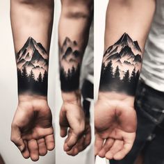 two men's arm tattoos with mountains and pine trees on the left side of their arms