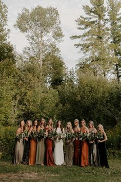 a group of women standing next to each other in front of trees