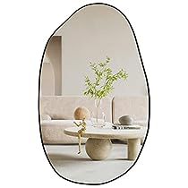 an oval mirror reflecting a living room with a couch and table in the reflection,