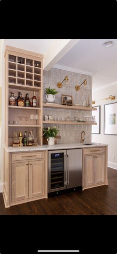 a kitchen with an oven, dishwasher and shelves filled with bottles on the wall