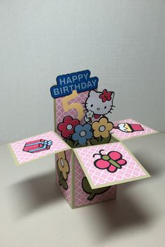 a hello kitty birthday card in a box with flowers and ladybugs on it